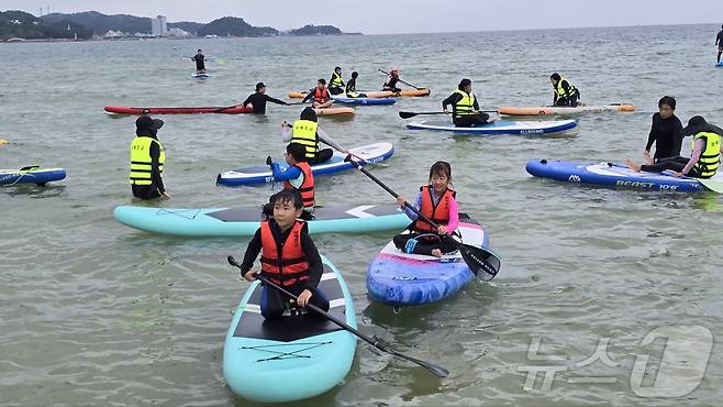 서핑 체험 하는 강원 양양 남애초 기존 학생들과 농어촌 유학생들.(남애초 제공)