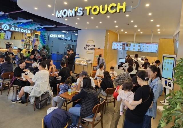 맘스터치는 물류, 재고 관리 등 가맹점주 부담을 덜기 위해 '싸이버거'를 비롯한 햄버거 제품에 사용하는 번 종류를 하나로 통일해 사용하고 있다. 사진은 맘스터치 몽골 1호 매장을 방문한 고객들이 식사하고 있는 모습. /맘스터치앤컴퍼니