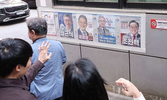 서울시교육감 보궐선거 사전투표 첫날인 11일 중구 소공동 사전투표소에서 직장인들이 공보물을 보고 있다. 연합뉴스