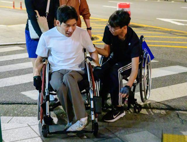 이도일씨가 4일 서울 용산구 이촌한강공원 일대에서 러닝 활동을 마친 뒤 복귀하다 횡단보도 근처 인도에 턱을 만나자 강사 김남영씨가 도움을 주고 있다. 최주연 기자