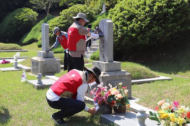 롯데이노베이트 임직원이 지난 5월 31일 현충일을 앞두고 현충원 묘역 단장 봉사를 하고 있다. 롯데이노베이트 제공