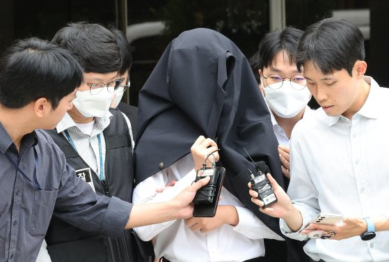 의료계 집단행동에 동참하지 않은 의사·의대생의 신상 정보가 담긴 블랙리스트 '감사한 의사'를 유포한 사직 전공의 정 모씨가 지난달 20일 서울 서초구 서울중앙지법에서 열린 구속 전 피의자 심문(영장실질심사)을 마친 뒤 경찰과 함께 이동하고 있다. 뉴스1