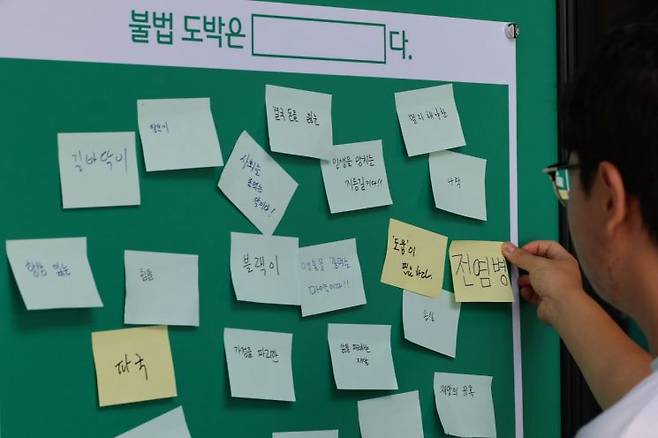 지난 8월 서울 마포구 하나은행 H-STAGE 1에서 청소년 불법도박 예방 선포식이 열린 가운데, 한 참석자가 청소년 불법 도박에 관한 생각을 적는 행사에 참가했다. [출처=연합뉴스]