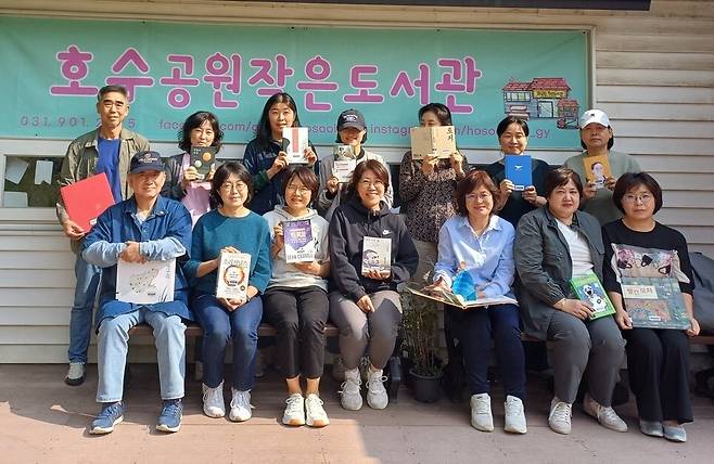 ‘도서관 지킴이’를 자처한 작은도서관 이용자들이 11일 경기도 고양시 일산동구 호수공원작은도서관 앞에서 책을 한권씩 들어보이고 있다. 이준희 기자