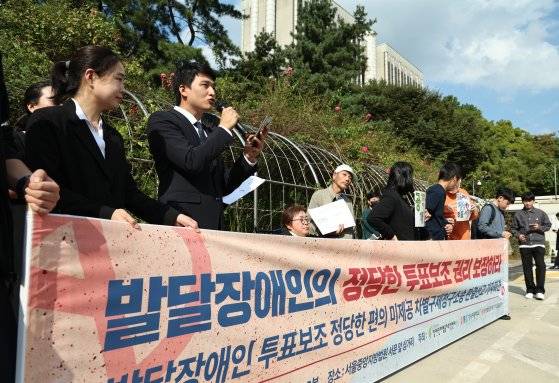 장애인차별금지추진연대 등 시민단체 회원들이 10일 오후 서울중앙지방법원 앞에서 중앙선관위를 상대로 낸 발달장애인 투표보조 편의 미제공 차별 구제 청구 소송에 대한 판결과 관련해 기자회견을 열고 입장을 밝히고 있다. 뉴스1