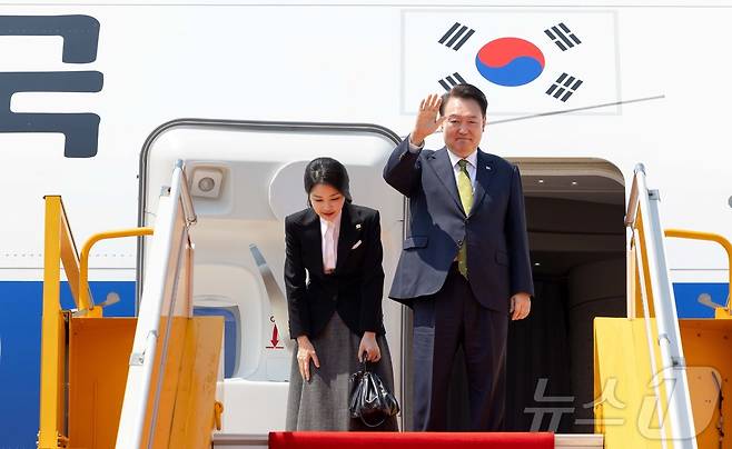 윤석열 대통령과 부인 김건희 여사가 11일(현지시간) 라오스 비엔티안 왓타이 국제공항에서 귀국하기 전 전용기에 올라 환송객들과 인사하고 있다. (대통령실 제공)/뉴스1 ⓒ News1 송원영 기자