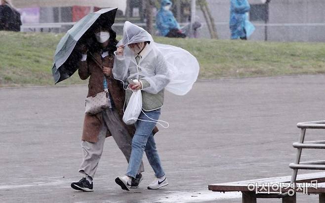 10일 서울 반포한강공원에서 시민들이 갑자기 불어온 비바람에 우산과 비옷을 움켜쥔 채 걷고 있다./김현민 기자 kimhyun81@