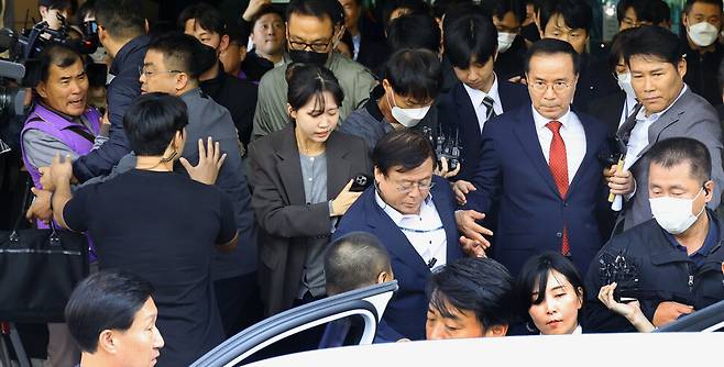 이태원 참사 책임자로 재판에 넘겨진 김광호 전 서울경찰청장(오른쪽 빨간색 넥타이 맨 사람)이 17일 서울서부지법에서 무죄를 선고받은 뒤 유가족들의 항의 속에 차량으로 향하고 있다. 윤운식 선임기자 yws@hani.co.kr