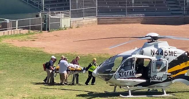 Salman Rushdie, in a video from Aug. 12, 2022, is seen being loaded onto a medical evacuation helicopter near the Chautauqua Institution after being stabbed in the neck while speaking on stage in Chautauqua, New York. [AFP/YONHAP]