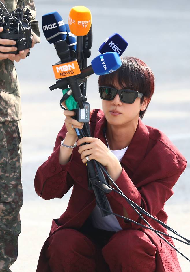 BTS member Jin holds the microphones for bandmate J-Hope on Oct. 17 in Wonju, Gangwon. [NEWS1]