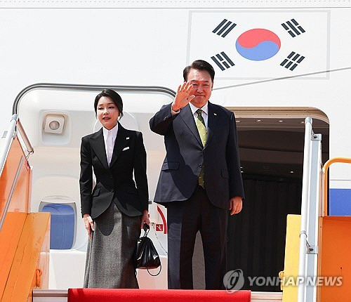 한일 정상회담과 아세안 정상회의 관련 일정을 마친 윤석열 대통령과 부인 김건희 여사가 지난 11일(현지시간) 라오스 비엔티안 왓타이 국제공항에서 귀국하기 전 전용기인 공군 1호기에 올라 손흔들어 인사하고 있다. [비엔티안=연합뉴스]