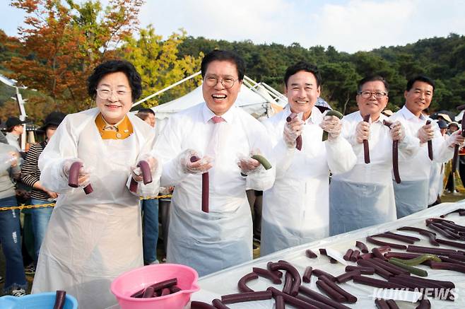 600m의 무지개 가래떡은 2000명이 30㎝씩 나눠 먹을 수 있는 양으로 쌀 3가마(240kg)가 사용되었다. 김경희 이천시장(왼쪽 첫 번째)과 귀빈들이 완성된 가래떡을 앞에 놓고 기념촬영하고 있다.