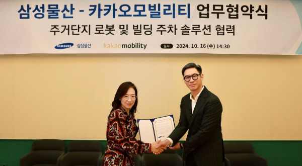 Chang Sung-wook, Head of Kakao Mobility’s Future Mobility Lab (right), and Cho Hye-jung, Head of Samsung C&T’s DxP Division, are taking a commemorative photo after the signing ceremony. (Kakao Mobility)