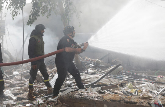 Civil defence members put out a fire at a damaged site, in the aftermath of Israeli strikes on Beirut‘s southern suburbs, Lebanon October 20, 2024.  REUTERS/Ali Alloush