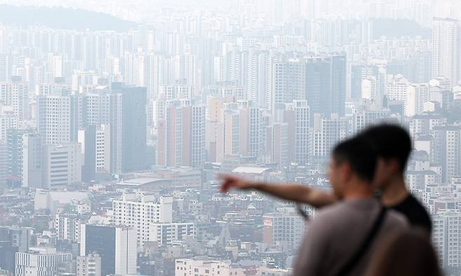 지난 15일 서울 남산에서 시민들이 도심 아파트 단지를 바라보고 있다. 뉴스1