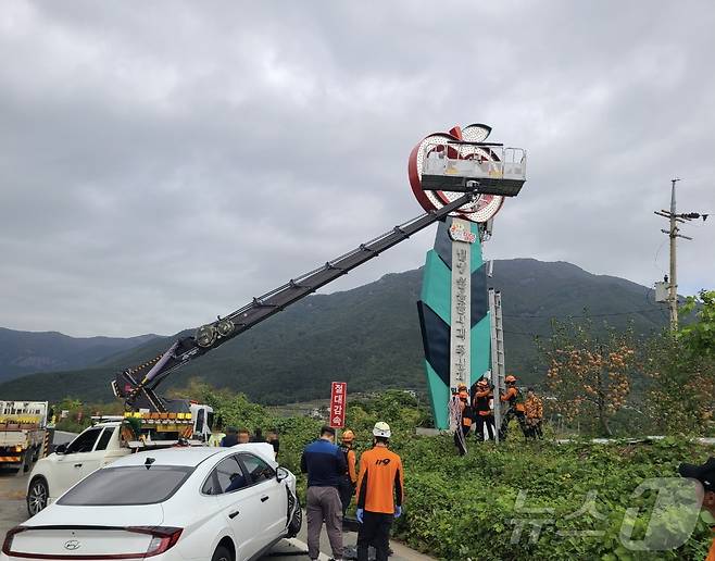 21일 오전 9시 50분쯤 밀양시 산내면 24번 국도에서 승용차가 광고판 교체 작업 중이던 3.5톤 크레인을 추돌해 고립된 작업자 2명을 소방이 구조하고 있다.(밀양소방서 제공)