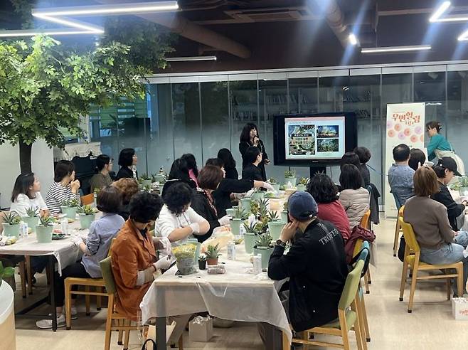 19일 서울 마포구 ‘청년문화공간 JU’에서 열린 한화손해보험의 ‘힐링 LIFE 프로그램’에 참석한 여성 암경험자와 보호자들이 식물을 활용해 작품을 만드는 ‘그린 테라피’ 활동에 적극 참여하고 있다.[사진제공=한화손보]