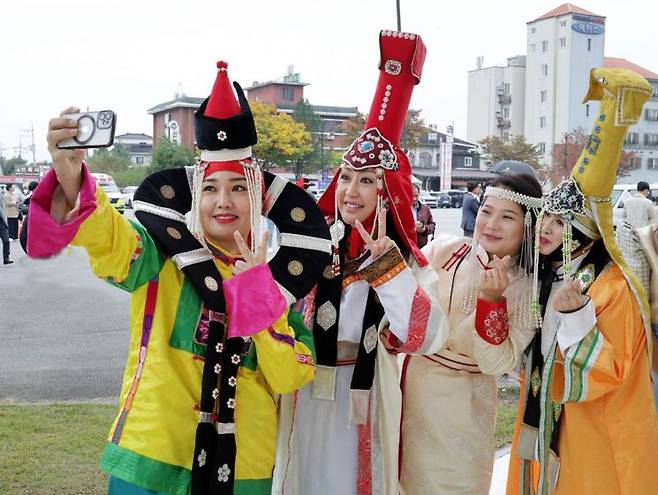 외국인들이 지난 18일~20일 신륵사관광지 일원에서 열린 '여주오곧축제' 현장에서 전통의상을 입은 채 휴대전화로 사진을 찍으며 즐거워하고 있다. ＜사진=여주시＞