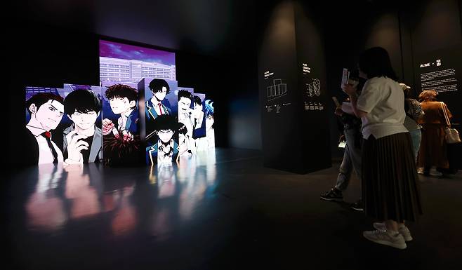 지난달 26일 오후 서울 성동구 에스팩토리에서 열린 2024 월드 웹툰 페스티벌을 찾은 관람객이 카카오엔터테인먼트 부스를 살피고 있다./연합뉴스