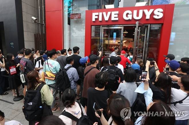 지난해 7월 한국 첫 매장을 개점하는 미국 햄버거 브랜드 '파이브가이즈' 강남점 앞에서 시민들이 햄버거를 사기 위해 줄을 서 있다. 연합뉴스