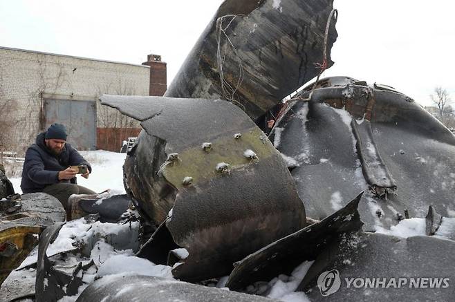 지난 1월6일(현지시간) 우크라이나 하르키우에 북한제로 추정되는 미사일 잔해를 한 남성이 촬영하고 있다.로이터연합뉴스