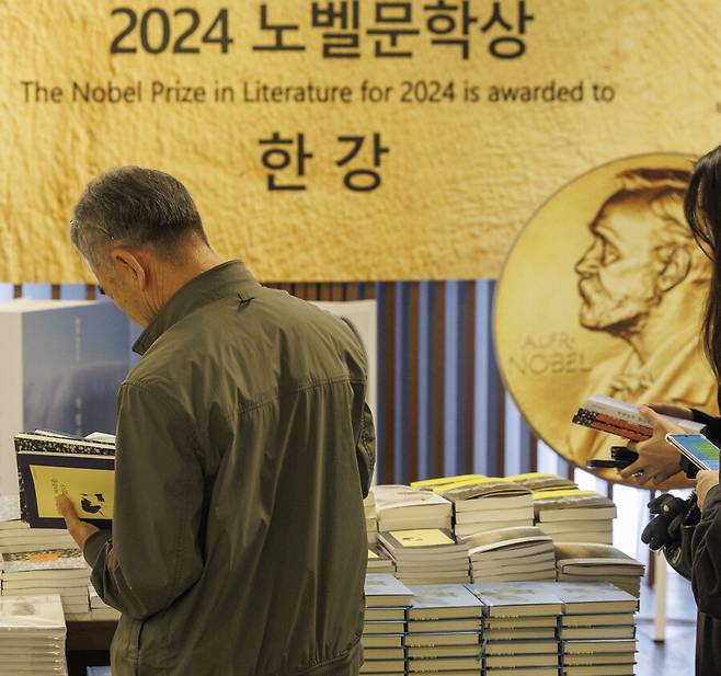 지난 16일 오전 서울 종로구 교보문고 광화문점을 찾은 시민들이 노벨문학상을 수상한 한강의 작품들을 고르고 있다. 연합뉴스