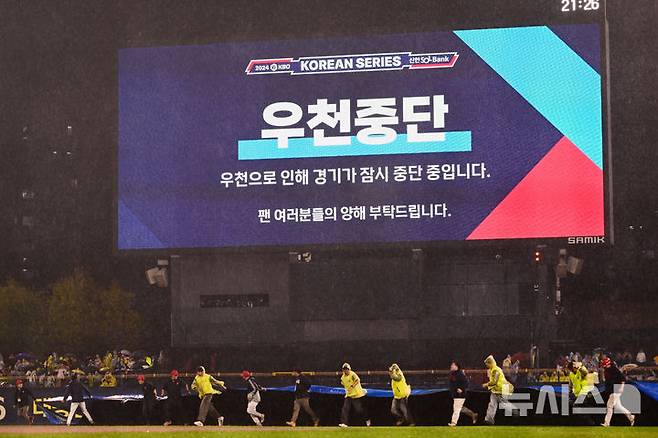 [광주=뉴시스] 이영주 기자 = 21일 광주 북구 광주-기아챔피언스필드에서 열린 2024 KBO 포스트시즌 한국시리즈 1차전 삼성 라이온즈와 KIA 타이거즈의 경기, 6회 초 경기 도중 우천으로 경기가 일시중단되고 있다. 2024.10.21. leeyj2578@newsis.com