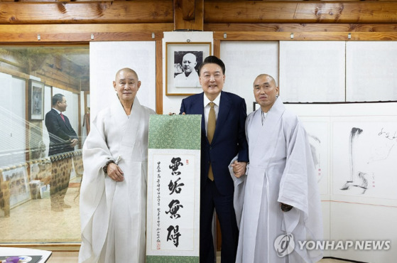 윤석열 대통령이 22일 부산 금정구 범어사를 찾아 차담 뒤 주지 정오 스님(오른쪽)이 쓴 무구무애(無垢無碍) 족자를 선물 받은 뒤 기념촬영을 하고 있다. 〈사진=대통령실, 연합뉴스〉