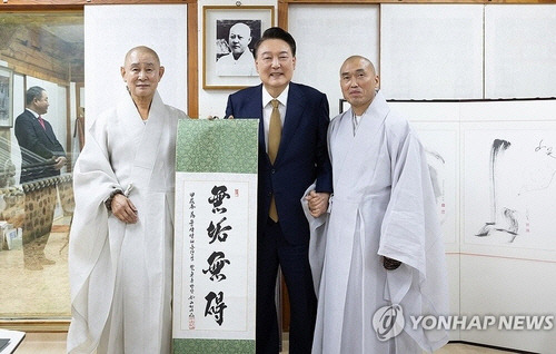 윤석열 대통령이 22일 부산 금정구 범어사를 찾아 차담 뒤 주지 정오스님(오른쪽)이 쓴 무구무애(無垢無碍) 족자를 선물 받은 뒤 기념촬영을 하고 있다. 왼쪽부터 방장 정여스님, 윤 대통령, 주지 정오스님. [대통령실 제공. 부산=연합뉴스]