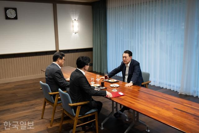 윤석열 대통령이 21일 서울 용산 대통령실 앞 파인그라스에서 국민의힘 한동훈 대표를 만나 대화하고 있다. 이 자리에는 정진석 대통령 비서실장이 배석했다. 대통령실 제공