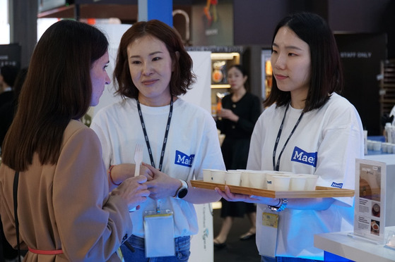 Maeil Dairies staff hand out tasing poritions of its Amazing Oat drinks at SIAL Paris.[MAEIL DAIRIES]