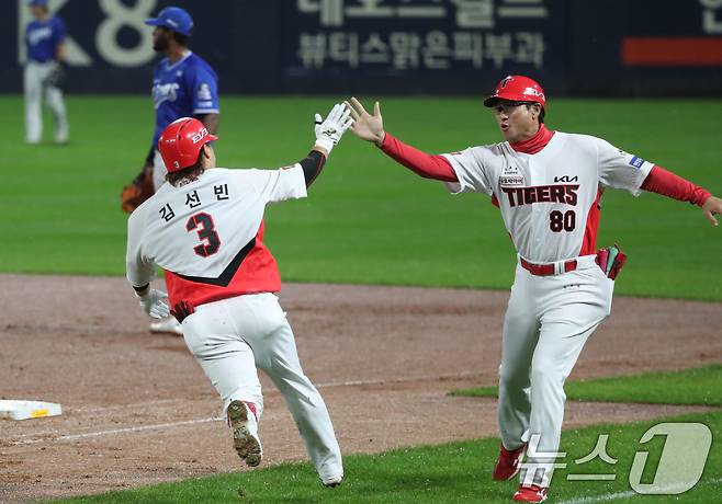 21일 오후 광주 기아챔피언스필드에서 열린 프로야구 '2024 신한 SOL 뱅크 KBO 포스트시즌' 한국시리즈 1차전 삼성 라이온즈와 KIA 타이거즈의 경기, 2회말 KIA 공격 2사에서 김선빈이 좌익수 방향 큼지막한 타구를 날린 후 홈런으로 판단하고 1루코치와 하이파이브를 하고 있다. 비디오 판독 결과 3루타. 2024.10.21/뉴스1 ⓒ News1 오대일 기자