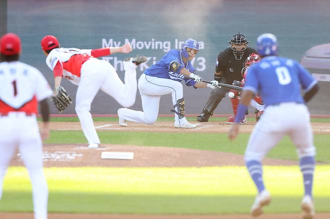 삼성 김영웅(가운데)이 23일 광주-기아 챔피언스 필드에서 열린 2024 KBO 한국시리즈 1차전 서스펜디드 게임 6회초 무사 1,2루에서 희생번트를 대고 있다. 사진 | 광주=연합뉴스