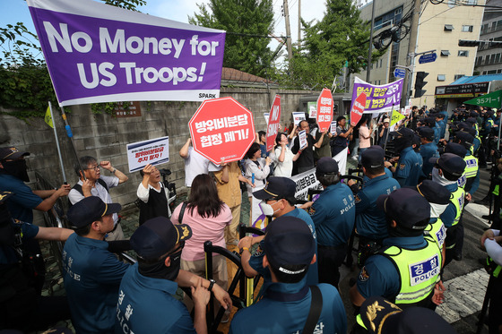 Members of a civic group shout slogans urging the cessation of "humiliating negotiations" over the 12th Special Measures Agreement between Korea and the United States near the Seoul Campus of the Korea National Defense University in Yongsan District, central Seoul, where the meeting is being held, on July 10. [NEWS1]