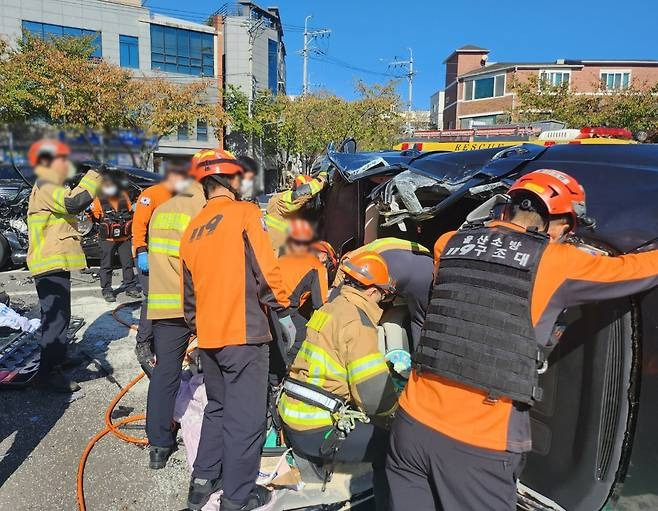 23일 울산 중구 성안동의 한 주차장에서 119 구조대원들이 차량 8대를 잇따라 들이받고 옆으로 넘어진 SUV 차량에서 운전자를 구출하고 있다. [사진 = 울산경찰청]