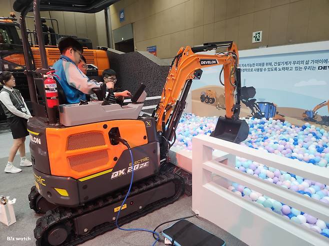 '한국국제건설기계전(CONEX KOREA 2024)'을 찾은 어린이 관람객이 HD현대인프라코어 직원의 안내에 따라 1.9톤 전기 굴착기를 체험하고 있다. /사진=도다솔 기자