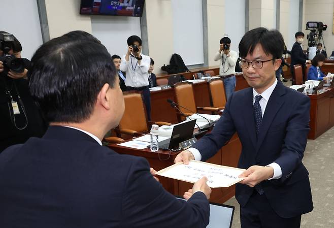  22일 국회에서 열린 교육위원회의 서울시교육청 등에 대한 국정감사에서 김영호 위원장이 담당 직원에게 국감에 불출석한 설민신 한경대 교수 고발장을 전달하고 있다. 연합뉴스