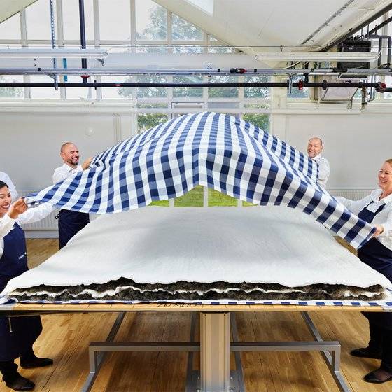 말총으로 만든 충전재 위로 여러 장인이 함께 블루 체크 원단을 씌우고 있다. [사진 해스텐스]