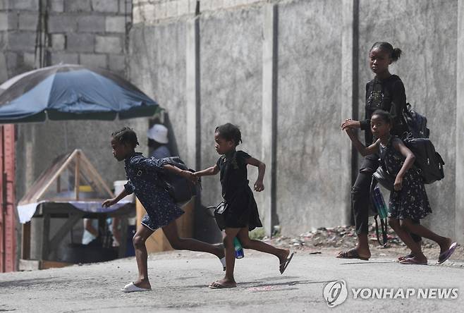 집 떠나는 아이티 가족 (포르토프랭스 로이터=연합뉴스) 지난 20일(현지시간) 아이티 포르토프랭스에서 한 여성이 아이 셋과 함께 갱단 폭력을 피해 집을 떠나 이동하고 있다. 2024.10.25