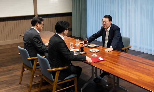 윤석열 대통령이 21일 용산 대통령실 앞 파인그라스에서 한동훈 국민의힘 대표와 차담을 하고 있다. 이날 윤 대통령과  한 대표는 직사각형 테이블을 사이에 두고 마주 앉았고, 한 대표 왼쪽에는 정진석 대통령실 비서실장이 자리했다./대통령실 제공