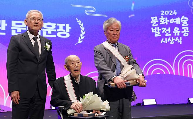 (From left) Culture Minister Yu In-chon, stage director Kim Jeong-ok and writer Yi Mun-yeol, recipients of the Geumgwan Order of Cultural Merit, pose for photos at a ceremony at Modu Art Theater in central Seoul on Friday. (Ministry of Culture, Sports and Tourism)