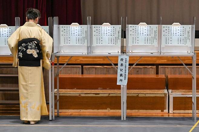 일본 중의원 선거가 치러진 27일 한 유권자가 투표용지를 투표함에 넣고 있다. AFP 연합뉴스