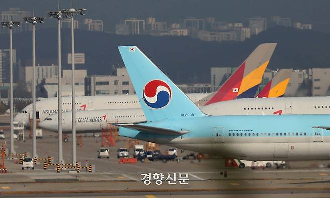 인천국제공항 주기장의 아시아나 항공기 앞 활주로로 대한항공 비행기가 지나가고 있다. 김창길기자
