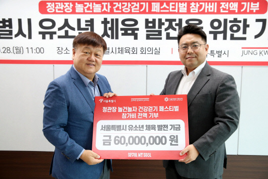 나태경(오른쪽) KGC인삼공사 마케팅혁신실장과 정규혁(왼쪽) 서울특별시체육회 사무처장이 서울 중랑구 서울특별시체육회에서 진행된 참가비 전달식에서 기념촬영을 하고 있다. KGC인삼공사 제공