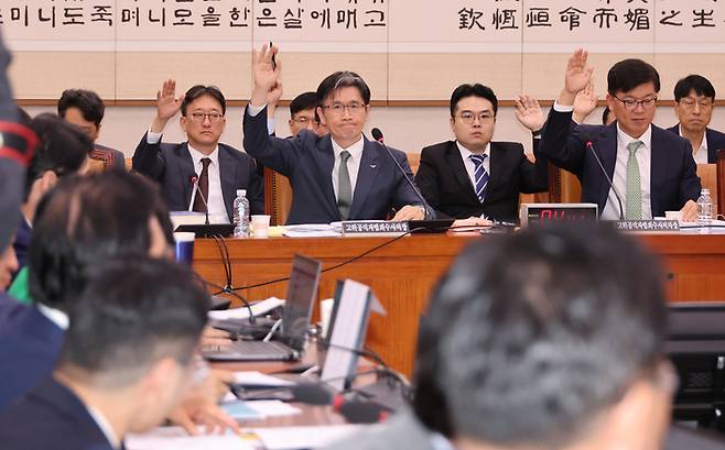 고위공직자법죄수사처(공수처) 오동운 처장과 이재승 차장을 비롯한 직원들이 지난 14일  국회에서 열린 법제사법위원회의 고위공직자범죄수사처에 대한 국정감사에서 “공수처가 존속돼야 한다고 생각하는 분은 손을 들어보라”는 국민의힘 곽규택 의원의 발언에 모두 손을 들고 있다. 연합뉴스