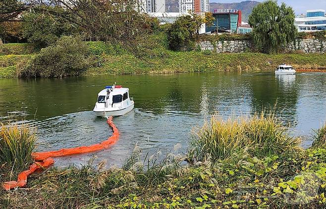 29일 양평군 남한강 양감섬에서 열린 수질오염사고 대응 합동훈련에서 남한강으로 추락한 유초자에서 흘러나온 기름이 확산되지 않도록 오일펜스를 설치하고 있다.(한강청 제공)