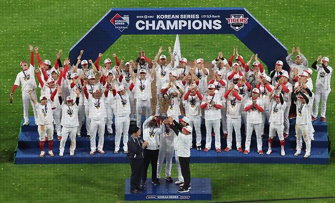 기아(KIA) 타이거즈 선수단이 28일 광주 기아챔피언스필드에서 열린 2024 KBO 포스트시즌 한국시리즈 시상식에서 통합우승을 달성한 뒤 우승 트로피를 들고 기념 촬영하고 있다. 연합뉴스