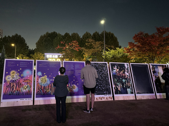 People read display boards explaining the Itaewon crowd crush during a memorial event held near City Hall in central Seoul on Saturday. [CHO JUNG-WOO]