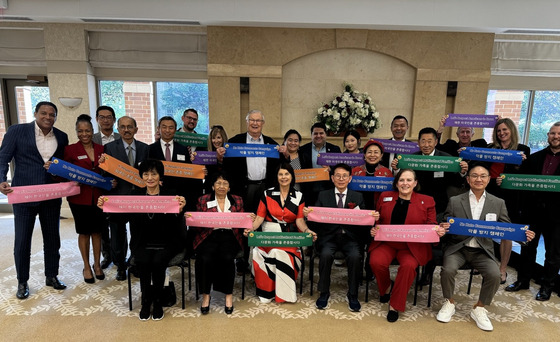 Min Byoung-chul, front row, third from right, and participants of the 2024 Northern Illinois University (NIU) Alumni Association Awards hold banners to respect foreigners and root out malicious comments at NIU in Illinois, United States, on Oct. 18. [SUNFULL FOUNDATION]