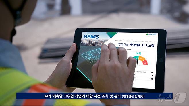 태블릿PC에서 HPMS 메인 화면을 가리키고 있는 현장 직원의 모습.(현대건설 제공)